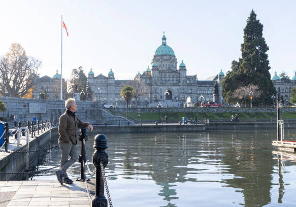 Mature man explores Victoria waterfront near BC Legislative buildings Mature man explores Victoria waterfront near BC Legislative buildings